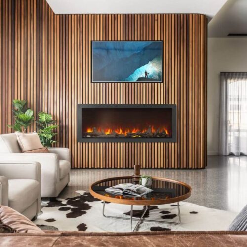 Living room with a vertical wood slat wall, a mounted TV above a linear fireplace, beige seating, and a round coffee table.